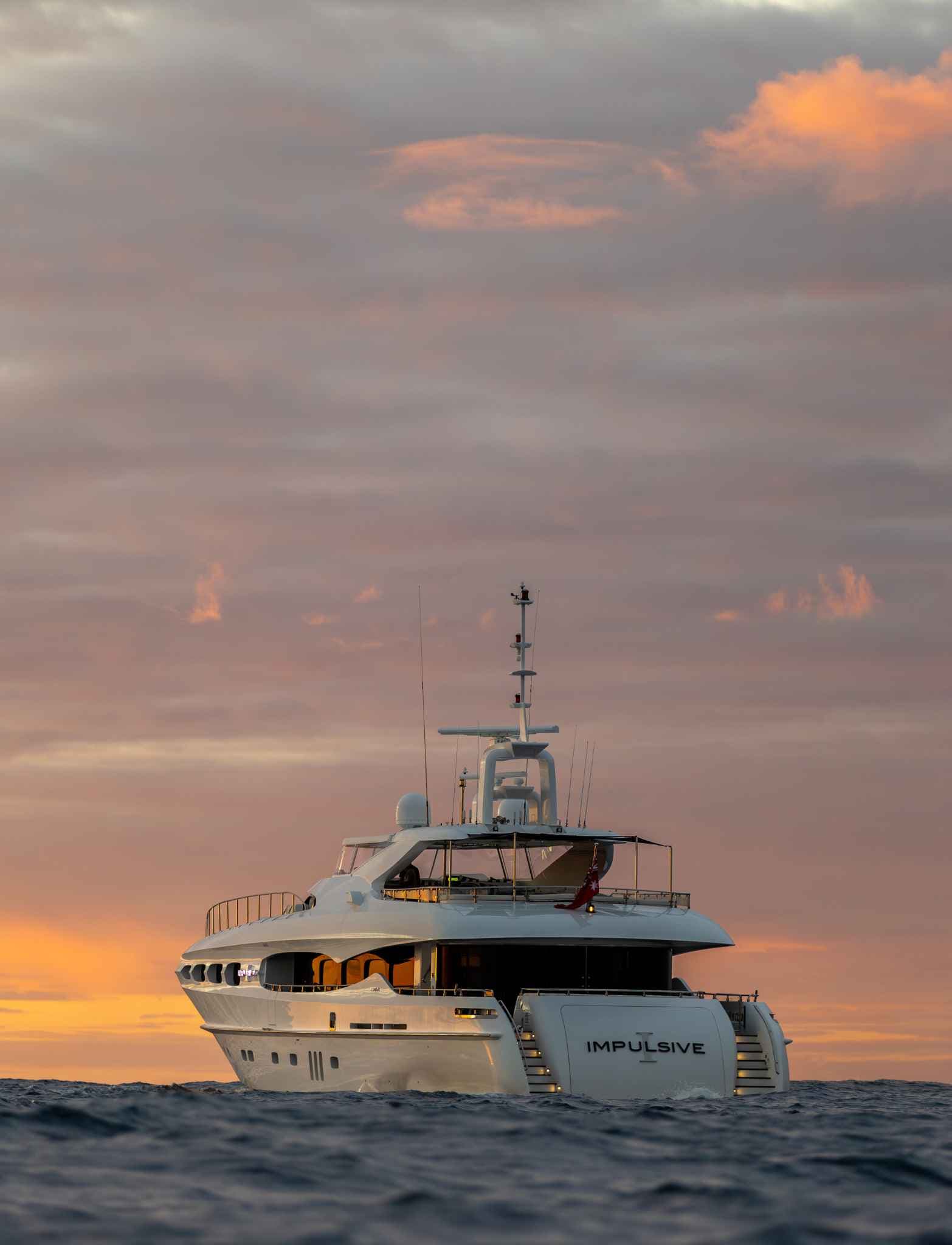 The motor yacht Impulsive at anchor on open water at dusk
